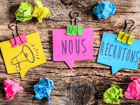 Post-it sur une planche en bois où il est écrit Nous recrutons