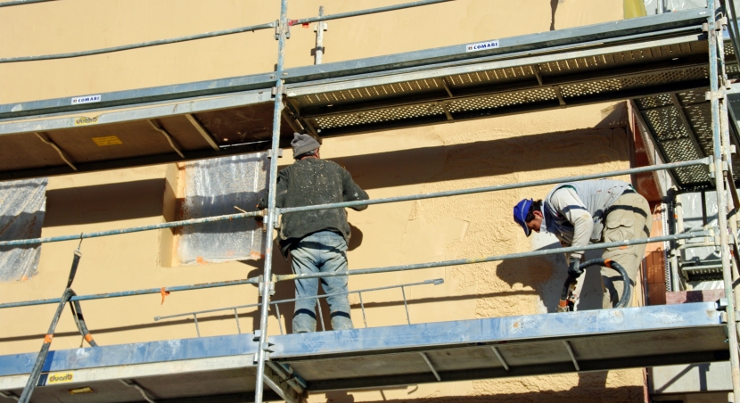Ouvrier sur des échafaudages pour le ravalement de façade
