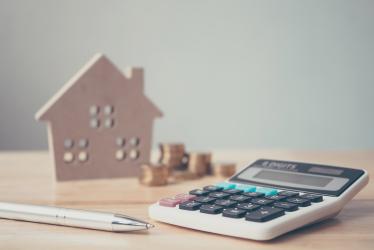 Taxe habitation - impots - finances  : un e calculatrice et un stylo devant une maison miniature